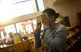 a person uses a Google Cardboard VR viewer at a public library