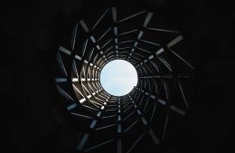 Tunnel-like view with a small circular opening to outside at the center, photo credit Aron Van de Pol / Unsplash