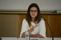 Sandra Ristovska seated being a table as she speaks. She is wearing black frame glasses and a white top.