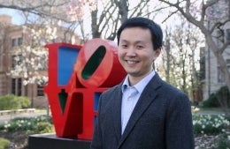 Kecheng Fang poses for photo in front of love statue at the University of Pennsylvania
