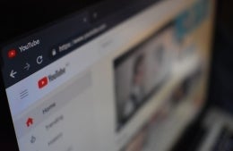Computer screen with Youtube homepage open. The video thumbnails on the screen are blurred; photo credit: Kon Karampelas / Unsplash