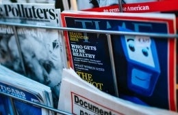 Magazine stand with TIME Magazine in focus with title "Who Gets to be Healthy"; photo credit: Markus Spiske / Unsplash