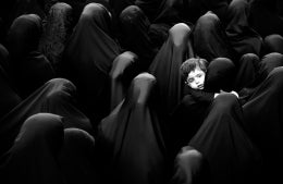 Child in crowd of women in full hijabs, photo credit Mehdi Sepehri / Unsplash