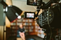 Video camera capturing video in library, photo credit Sam McGhee/Unsplash