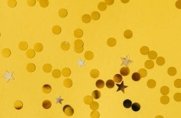 golden dots and stars on top of a yellow background, photo credit Nataliya Vaitkevich / Pexels