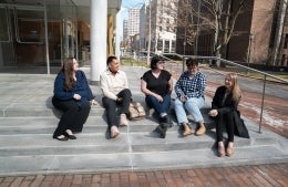 Students from Annenberg and SP2's inaugural Executive Program in Digital Media for Social Impact cohort sit outside talking and smiling: Stephanie Viggiano, Michael Ticzon, Megan Hurson, Jennifer Ingham, and Amanda Labrador. 