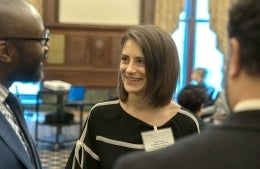 Candid of Julia Ticona wearing a nametag and smiling at Dean Jackson
