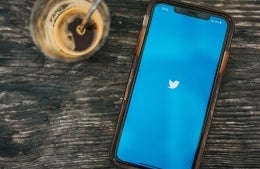 mobile phone on a table with a blue screen and a white twitter bird in the center photo credit: nathan dumlao - unsplash