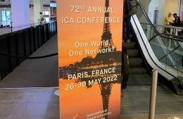 Vertical ICA banner reading "72nd Annual ICA Conference / One World, One Network? / Paris, France 26-30 May 2022" in front of an escalator