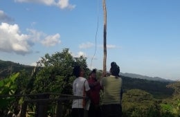 An image of three people putting up an antenna