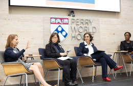 Antonia M. Villarruel addresses the audience while Emily Hannum, Tulia Falleti, and LaShawn Jefferson look on. A sign behind the group reads: Perry World House. 