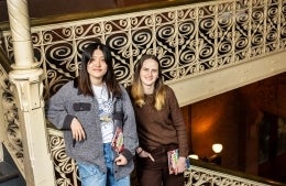 Gemma Hong and Sophie Young standing together holding copies of their book.