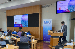 Professor Victor Pickard speaks at a podium to an audience 