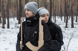  Students Vadym Beilakh and Sofia Chygyryn stand in a snowy forest holding wooden replicas of weapon