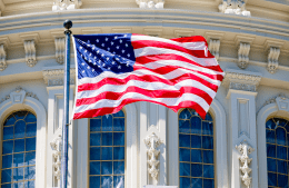 The American Flag waves in front of the Capitol building in Washington D.C.