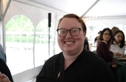 Kate Okker-Edging in a tent with several people in the background