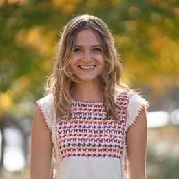 Madison Miller smiling and standing against blurred background