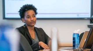 Jazmyne Sutton Dissertation Defense.jpg Woman seated at a table while talking