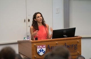 Kelly Diaz standing at an Annenberg podium speaking