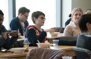 Megan Genovese speaking while seated in an audience of students