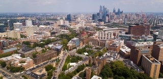 Aerial view over Penn's campus with the skyline of Philadelphia in the background