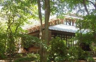 American Academy of Arts and Sciences building nestled among trees and other greenery, photo credit Daderot / en.wikipedia