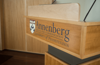 close shot of a wooden podium with the words "Annenberg School for Communications" on the front