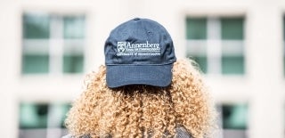 Woman with curly hair viewed from behind wearing an Annenberg hat backwards