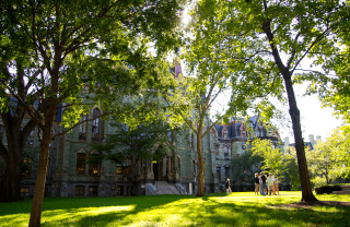 Houston Hall, a green stone building on Penn's campus, surrounded by trees and green grass, photo credit Scott Spitzer / University of Pennsylvania