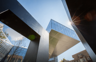 a modern architecture building on Penn's campus with a blue sky and sunshine in the background, photo credit Scott Spitzer / University of Pennsylvania