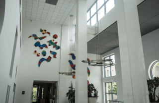 white room with colorful abstract art on top side of the wall, above the entrance 