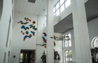 white room with colorful abstract art on top side of the wall, above the entrance