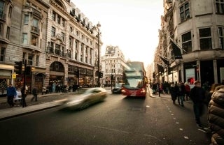 busy street with cars moving and people walking, photo credit David Marcu / Unsplash