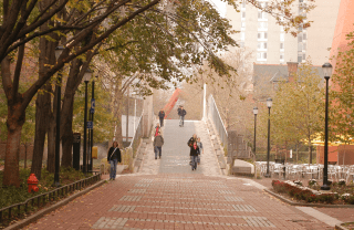 people walking across Locust Walk bridge