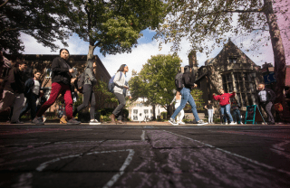 low angle view of students walking down Locust Walk on a bright day