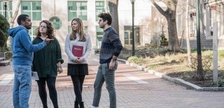 Four students standing outside talking