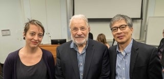 Three people posting for a photo in a classroom