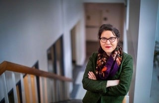 Muira McCammon standing on a staircase with her arms folded, photo credit Eric Sucar