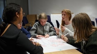 AHA_Research_FW_1920x1070.jpg Group of students around a table having a discussion