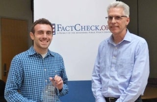 Corey Berman holding his award and standing next to Eugene Kiely, director of FactCheck.org