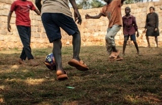 ground level shot of children playing soccer, photo credit Belle Maluf / Unsplash