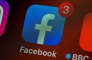 Photo of the Facebook app on an iOS interface. The app is blue, with a white common f in the middle 'sitting' on the bottom of the rounded-square. In the top right in a red circle with a white number 3 centered in it. photo credit Brett Jordan/Unsplash