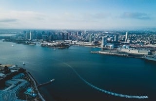Photo of a water body in San Diego, with infrastructure on either side, photo credit Daniel Guerra / Unsplash