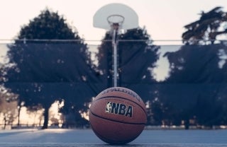 basketball in a basketball court with the words "NBA" on it; photo credit: Edgar Chaparro / Unsplash