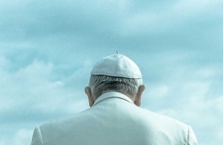 Back view of a Pope from the upper back-up wearing the white Zucchetto and white cassock. photo credit Nacho Arteaga / Unsplash