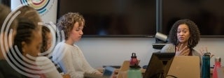 Woman giving a lecture to group at conference table