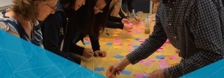 People organizing sticky notes on a table for a project