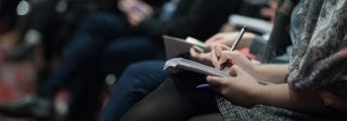 A line of people writing in notebooks, Photo Credit The Climate Reality Project / Unsplash