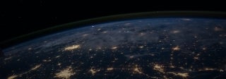 View of the earth from outer space with the lights of cities prominent, photo credit NASA / Unsplash