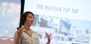 Jessa Lingel talking in front of a screen that says "The Haitian Tap Tap"